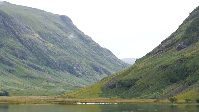 Still slow motion landscape shot of lake and green mountains in Scottish Highlands Edinburgh UK 19280x1080 HD