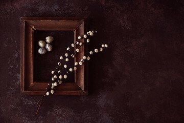 Old wooden frame with spring flowers and leaves on rustic wooden background. Spring flowers composition with copy space.