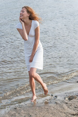 Pretty woman in a white dress on coast