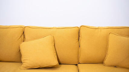 Yellow canvas sofa with two pillows on it