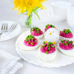 Boiled eggs stuffed with beetroot paste and sprinkled with chives.