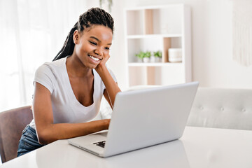 school girl sitting at home with laptop