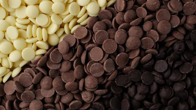assorted chocolate chips from white, milk, black chocolate top view. confectionery concept