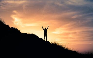 Male hiker on top a mountain celebrating victory. Reaching your goals and inspiration concept. 