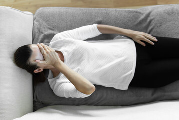 Fototapeta na wymiar Stressed worried woman lying on sofa