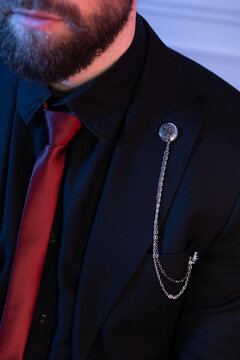 Men's beard. Formal suit with a red tie. Photo of men's details.