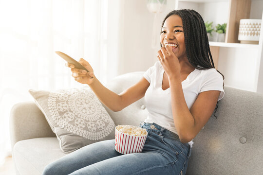 Portrait of teenager watching tv with pop corn on hand