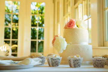 Wedding cake on table in restaurant decorated with flowers