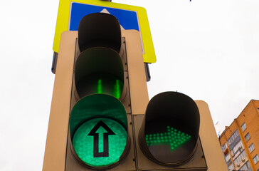Traffic light with a burning green light on the street