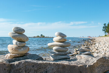 Pyramids of stacked stones on rock on beach of Lake Baikal, scenic seascape, balance and harmony concept