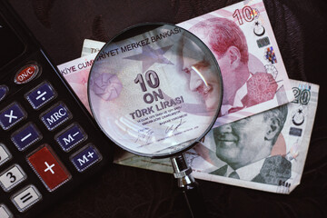 Turkish lira bills seen through a magnifying glass and a calculator