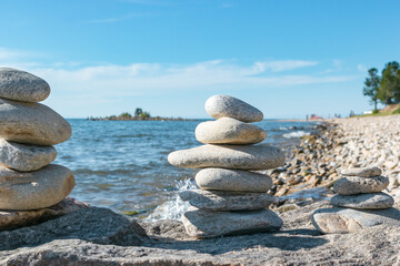 Pyramids of stacked stones on rock on beach of Lake Baikal, scenic seascape, balance and harmony concept