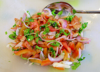 Red tomato,Coriander Leaves and green chilli  salad in glass bowl.