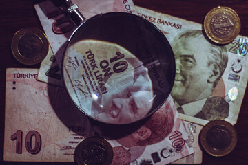Turkish lira bills seen through a magnifying glass and coins