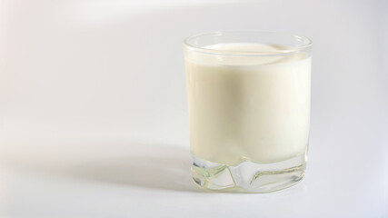 Glass of plant organic milk with shadow on white background