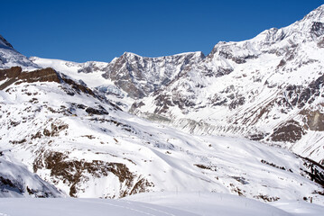 Fototapeta na wymiar Snow capped mountains, snowfields and glaciers at Zermatt, Switzerland, seen from Gornergrat railway station. Photo taken March 23rd, 2021.