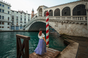 Happy young girl traveling in venice with rialto bridge in background - obrazy, fototapety, plakaty