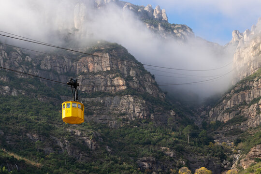 Teleferico de Montserrat con niebla, rocas y cielo.