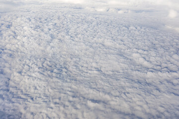 Fluffy clouds that looks as flat surface as seen from commercial airplane