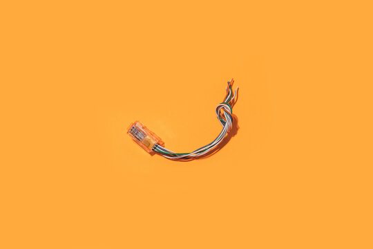 Top view minimalistic layout of bunch of multicolored electric cables on bright yellow background