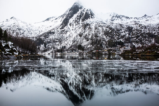 Magnificent scenery of sea and mountains under gray cloudy sky in winter in Norway