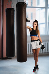 Female fighter trains her punches, training day in the boxing gym, the girl trains a series of...