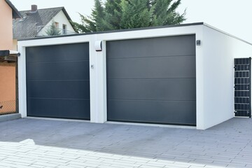 Moderne Beton-Garage mit Automatik-Tor in der Wohngebäude-Zufahrt