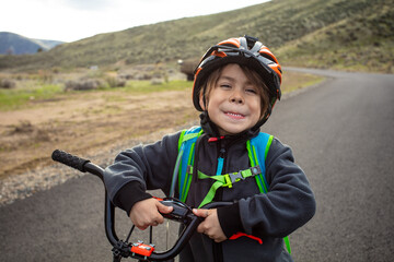 Smiling kid holding the frame of his bike