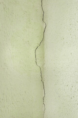 Crack on the old plaster wall surface in the ceiling corner of the building facade texture background