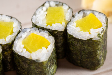 Maki rolls with mango and fresh rice, wrapped in nori on plate closeup - 423073445