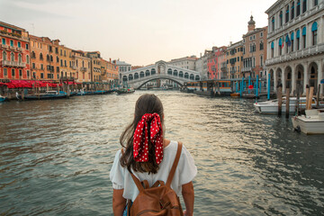 Happy young girl traveling in venice with rialto bridge in background