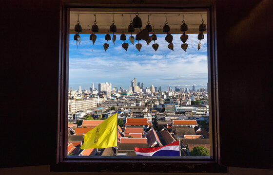 Spectacular cityscape of Bangkok with contemporary buildings from window of famous Wat Saket Buddhist temple against cloudy blue sky