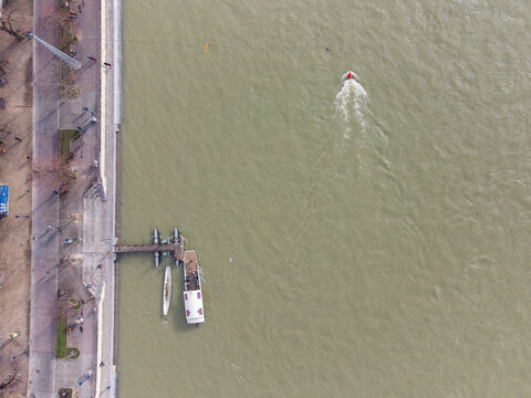 Top Down Aerial Drone Shot Of A Small Ferry Boat Over The Rhein River In Basel City Center, Switzerland During High Water