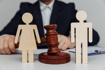 Lawyer or counselor holds gavel behind of figures of young family, divorce or separation concept