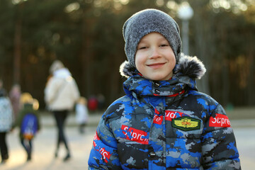 The little boy smiles as he looks at the camera close up