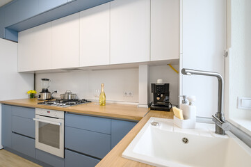 Fototapeta na wymiar Modern blue-teal colored furniture kitchen interior