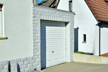 Moderne Beton-Garage mit Automatik-Tor in der Wohngebäude-Zufahrt