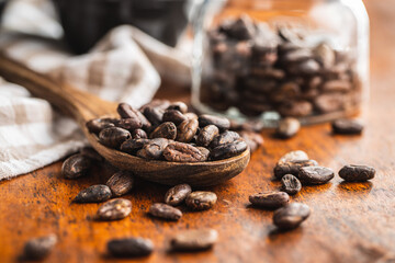 Roasted cocoa beans in wooden spoon
