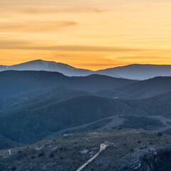 Naklejka premium cielo amarillo sobre las montañas, niebla entre las montañas, vista panorámica de las colinas al atardecer