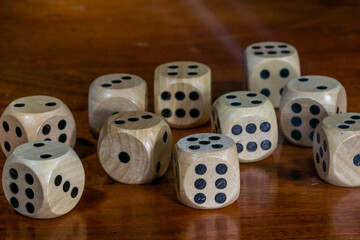 Wooden dice for board game on wooden table.