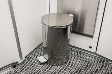 Metal trash can in a modern toilet in an electric train