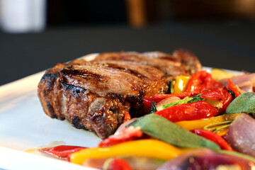 Ancho or Rib Eye. Steak on restaurant plate with colorful low carb vegetables