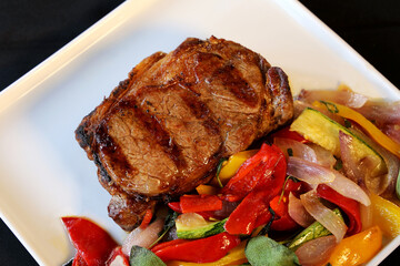 Ancho or Rib Eye. Steak on restaurant plate with colorful low carb vegetables