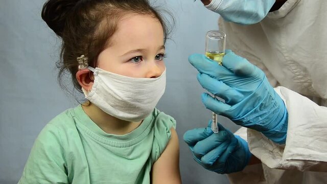 The child is vaccinated against Covid-19. Vaccination of children against coronavirus. A doctor vaccinates children during a coronavirus outbreak. Children's vaccination against coronavirus