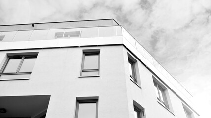 Part of city real estate property and condo architecture. Detail in modern residential flat apartment building exterior. Fragment of new luxury house. Black and white.