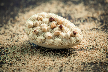 Stuffed white chocolate easter egg with hazelnuts and cashew nuts on a wooden table. Gourmet.
