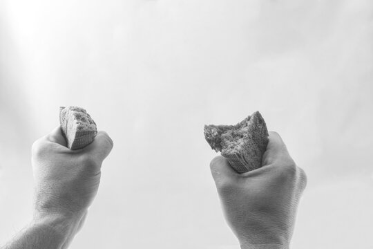 Chono white photograph of male hands with two pieces of bread, the value of bread