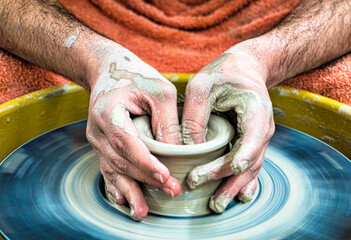 hands of a potter at his potter's wheel