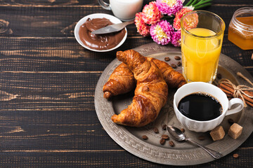 Croissant with chocolate hazelnut spread and cup of coffee