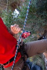 man climbing a mountain with rope